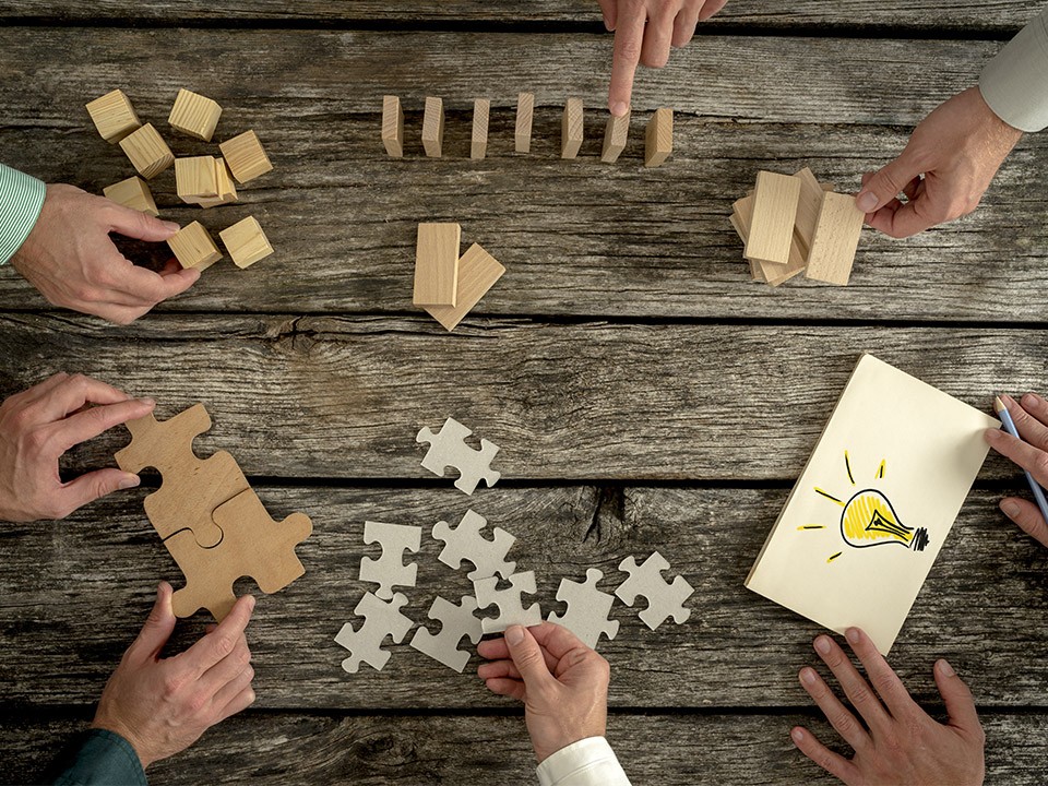 Ljudje sestavljajo puzzle, domine ...