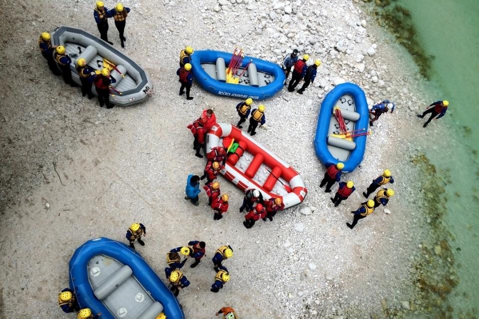Udeleženci nosijo rafte v vodo
