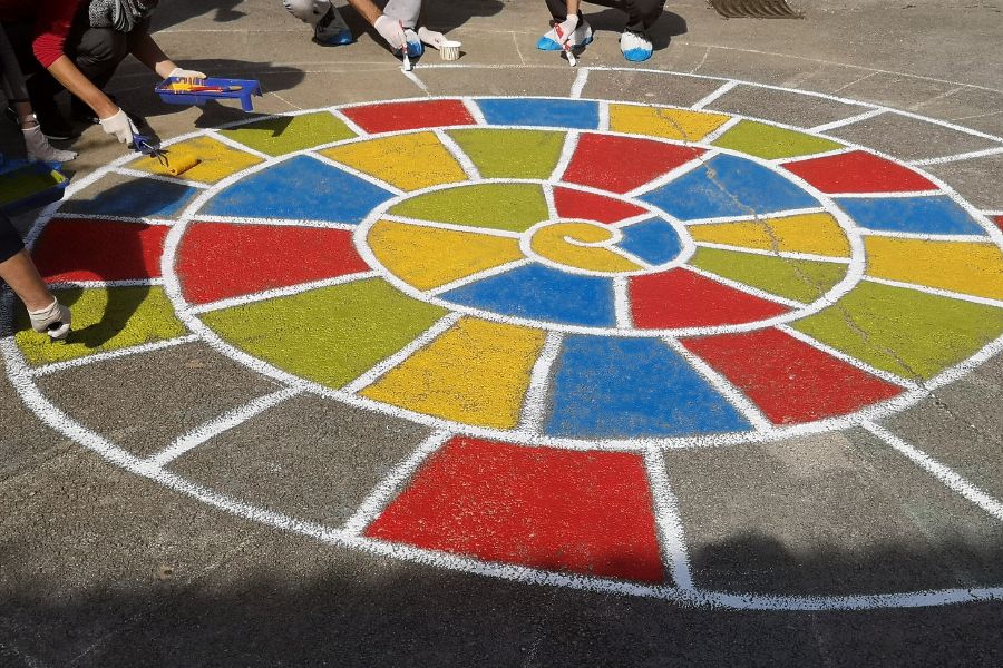 Udeleženci team building programa obnavljajo otroško igrišče