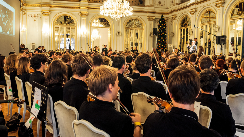 Skupina ljudi na novoletnem team building dogodku igra violine