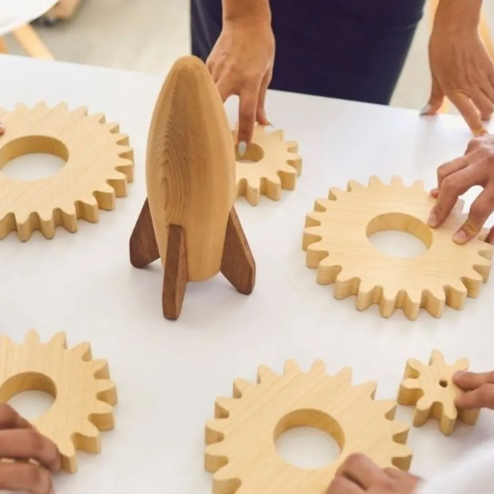 People fitting gears around a rocket representing teamwork