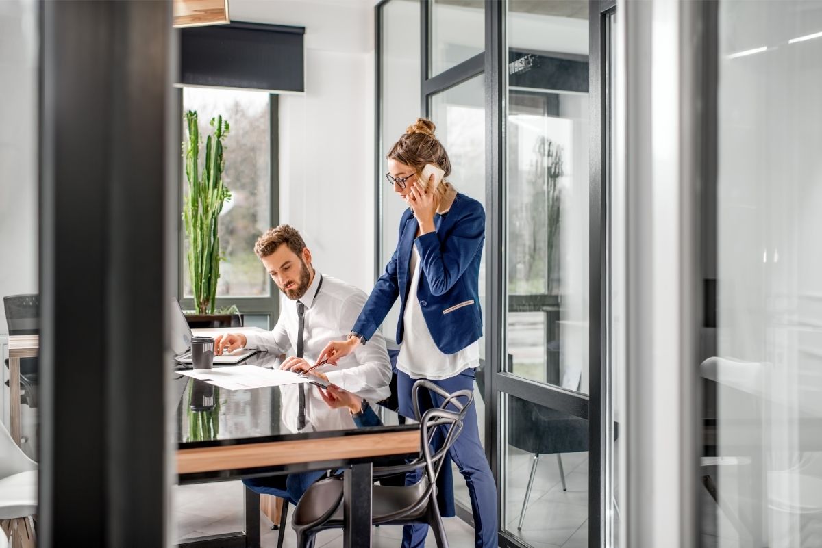 Coworkers standing next to a desk